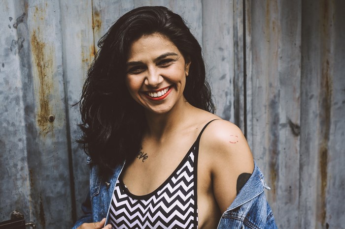 Woman with tattoos wearing a denim jacket