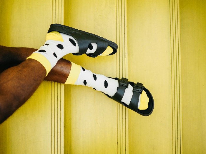 Man wearing black Birkenstocks and polka dot socks