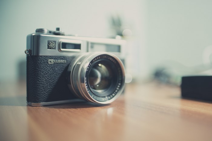 Yashica film camera with lens on wooden table