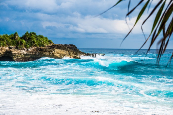Waves crashing on rocky shore of Nusa Lembongan
