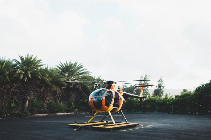 Orange and yellow helicopter on a landing pad
