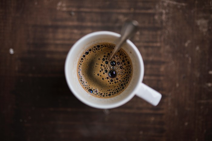 Top-down view of coffee in a mug with a spoon