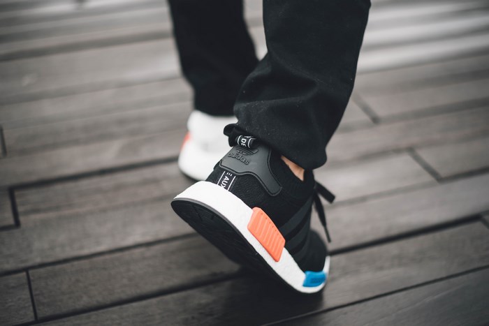 Adidas NMD R2 sneakers on wooden planks