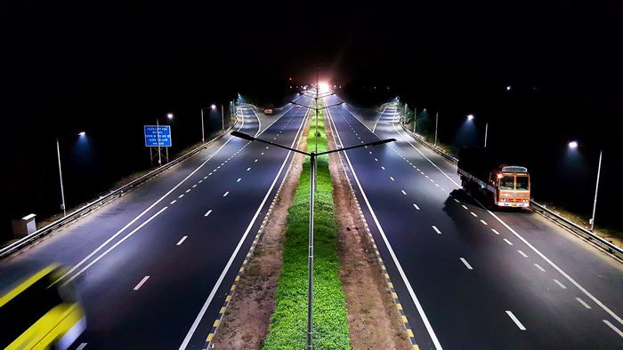 Night highway with street lights and vehicles