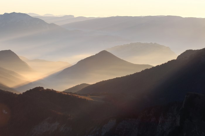 Mountain range with fog and sunlight at sunset