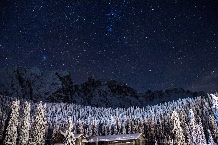 Winter night sky over snow-covered Dolomites, Italy