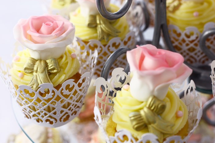 Yellow cupcakes with pink roses and gold bows