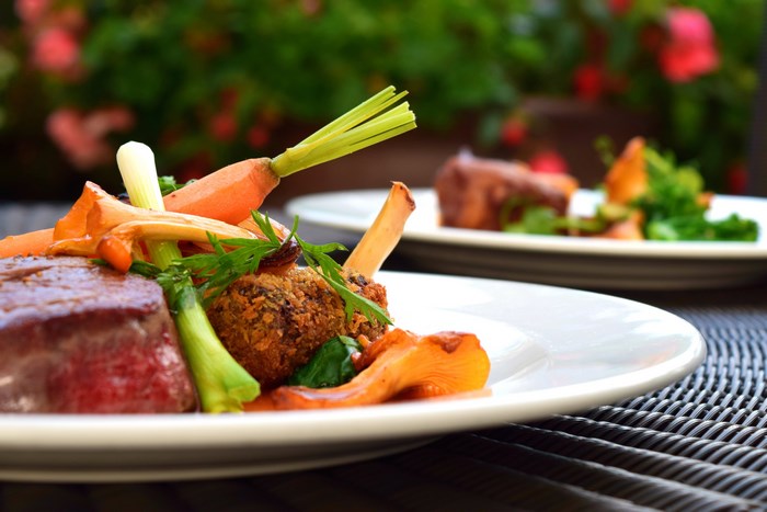 Gourmet dish with meat, carrots, and spring onions