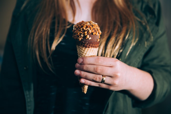 Woman holding a chocolate nut ice cream cone