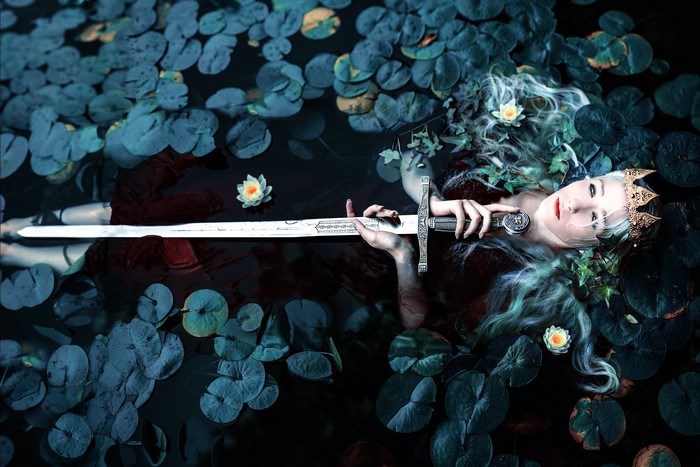 Fantasy woman with sword and crown in water