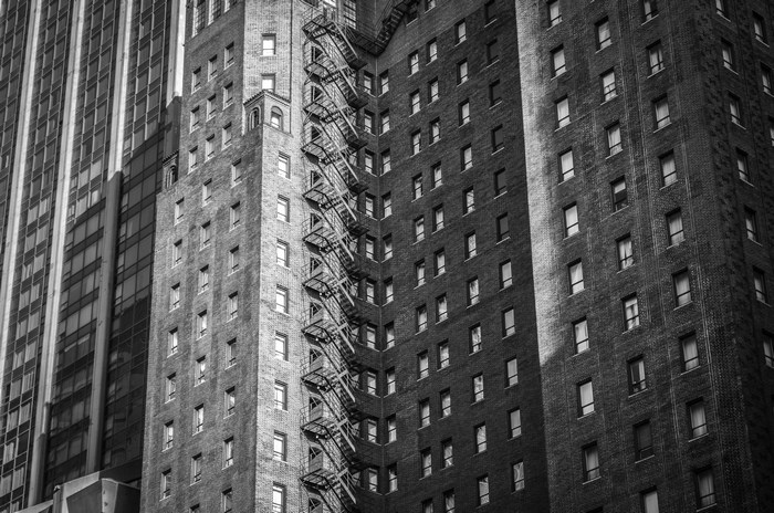 Black and white image of buildings with fire escape