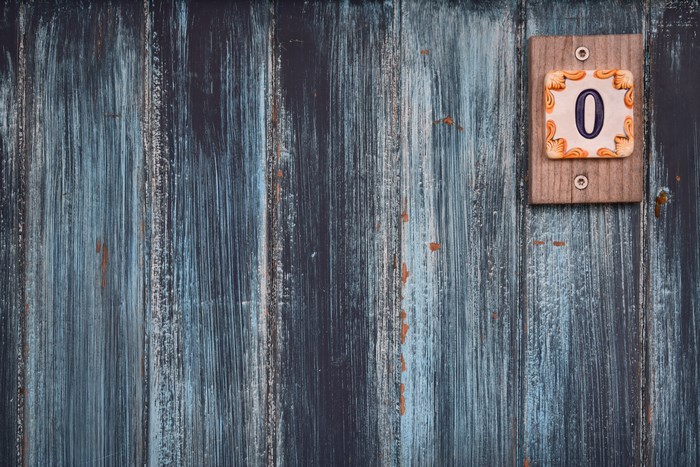 Number 0 plaque on a weathered blue wooden door