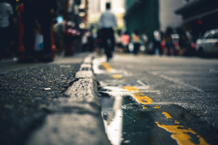 Wet city street with yellow line and blurred people