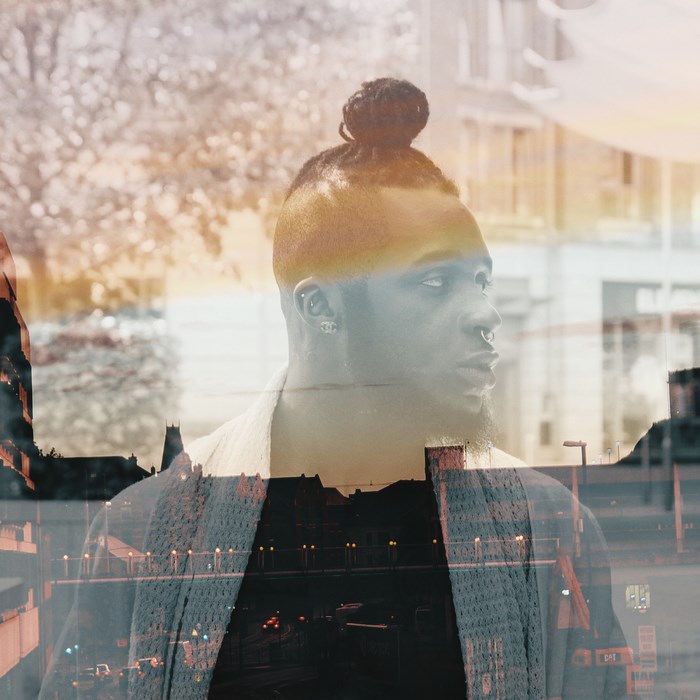 Double exposure portrait of a Black man with a manbun