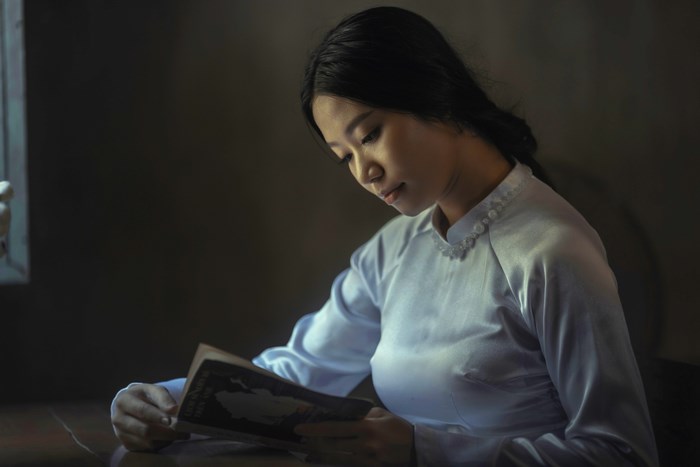 Woman in Ao Dai reading a book