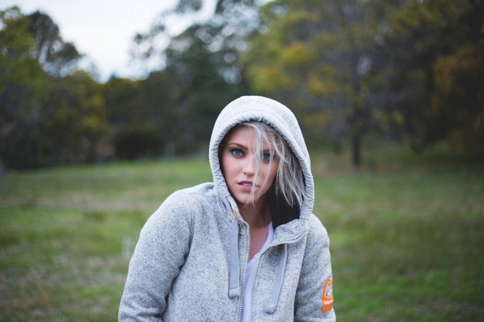 Woman in a grey hoodie in a field