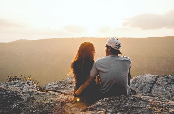 Couple sitting on a cliff at sunset in North Carolina