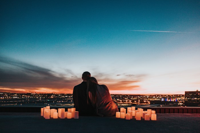 Couple on a rooftop with candles at sunset