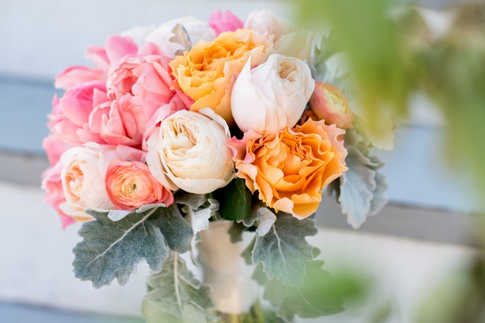 Wedding bouquet with pink, orange, and cream roses