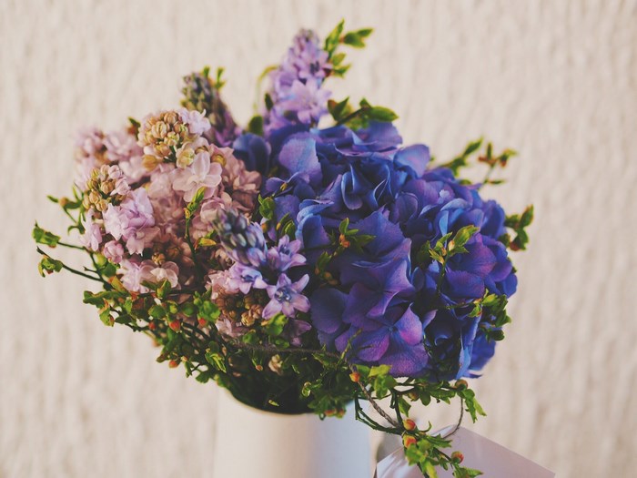 Purple and pink flowers in a white vase