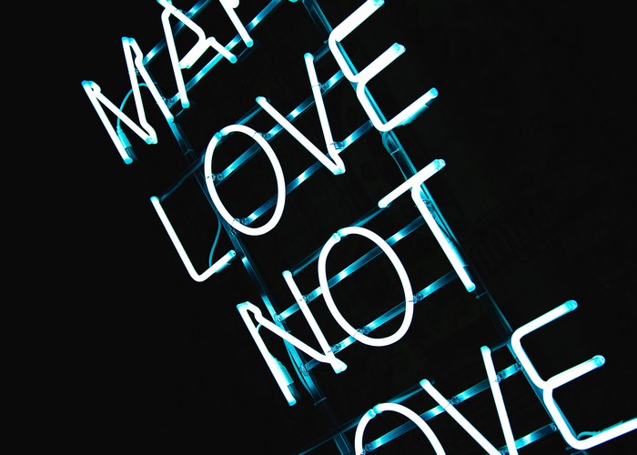 Blue neon sign with text 'LOVE NOT LOVE'