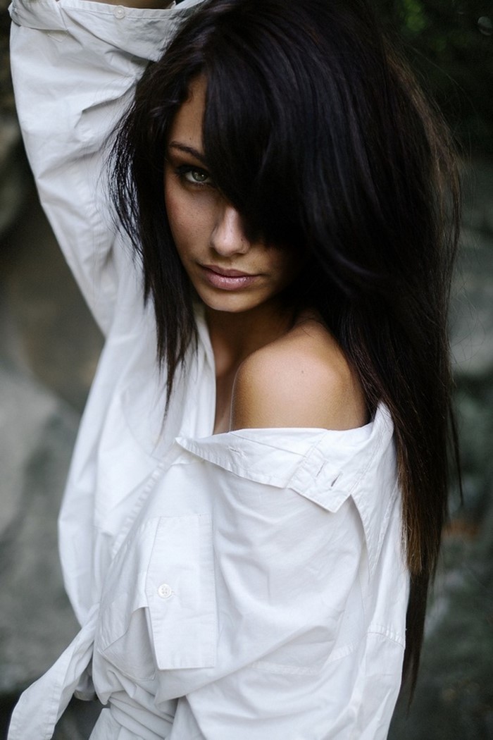 Woman with black hair and green eyes in white shirt