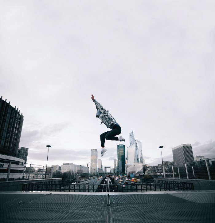 Person jumping over a highway in a city