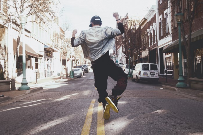 Man jumping in the street with yellow lines