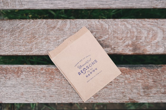 Brown paper bag with quote on wooden bench