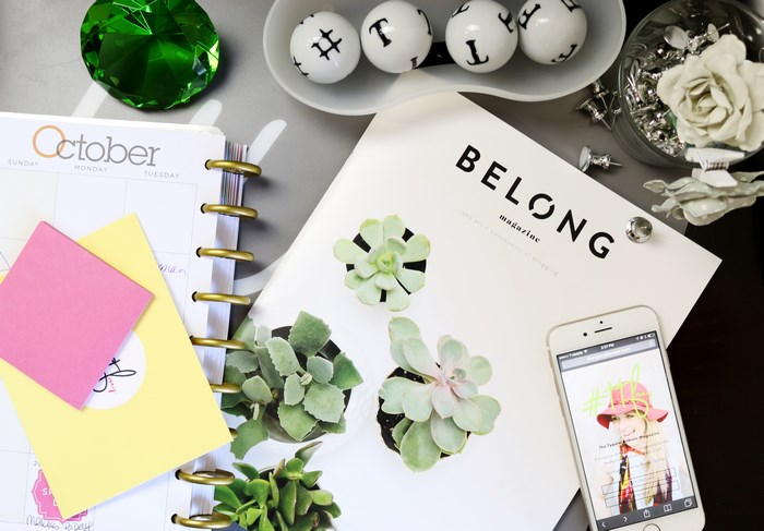 October calendar, Belong magazine, and succulents on a desk