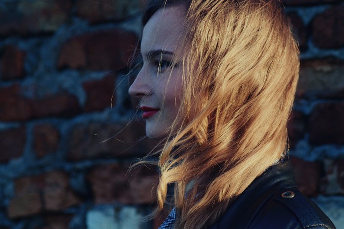 Woman in leather jacket with windblown hair