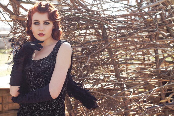 Woman in elegant dress and gloves posing outdoors
