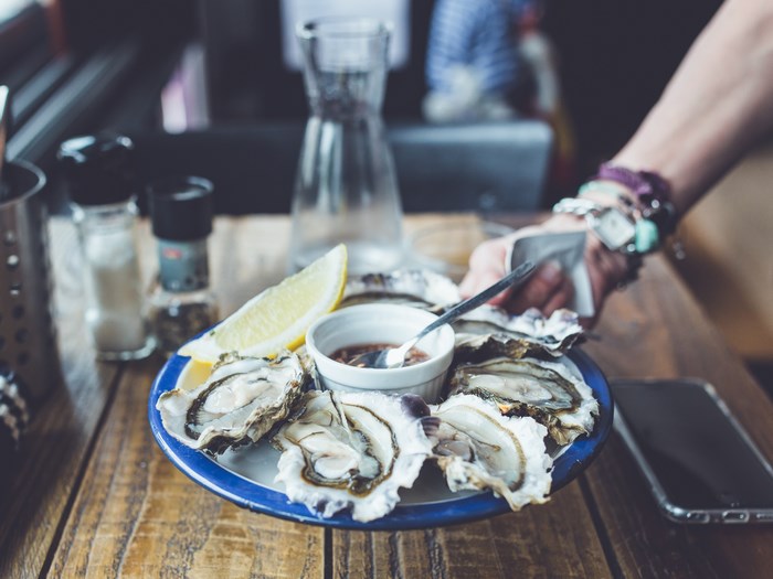Plate of oysters with lemon and dipping sauce