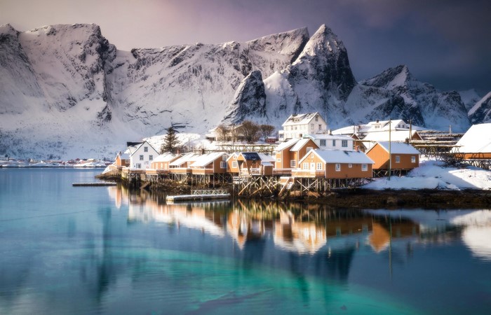 Winter village in Lofoten, Norway with snow-capped mountains