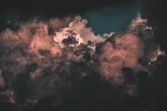 Dark and pink clouds against a teal sky