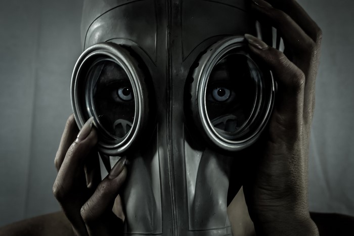 Woman wearing a gas mask with blue eyes