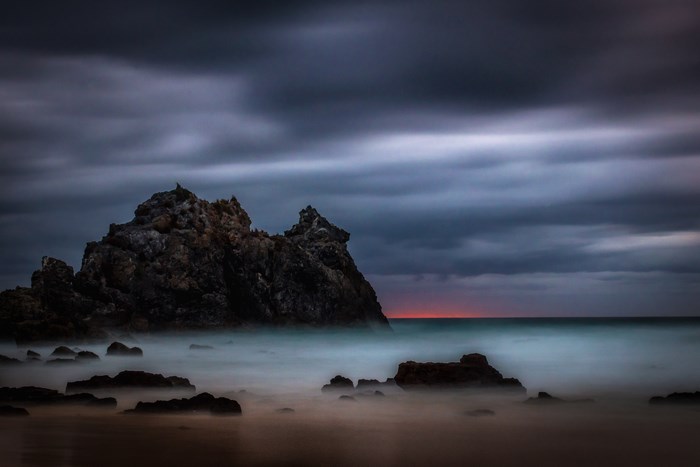 Long exposure of rocky coast at dawn with cloudy sky