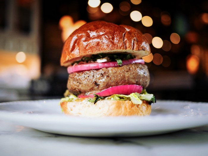 Gourmet burger with brioche bun and red onion