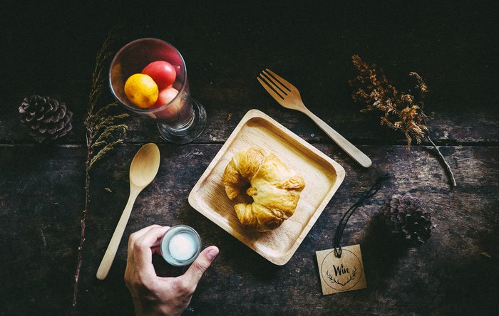 Croissant, fruit, and milk on a wooden table