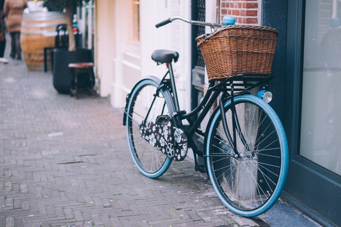 Retro bicycle with a wicker basket on a cobblestone street