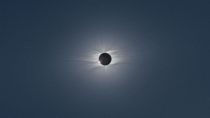 Solar eclipse with corona and stars