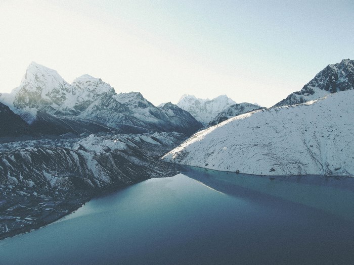 Snowy Himalayan mountains reflected in a glacial lake in Nepal