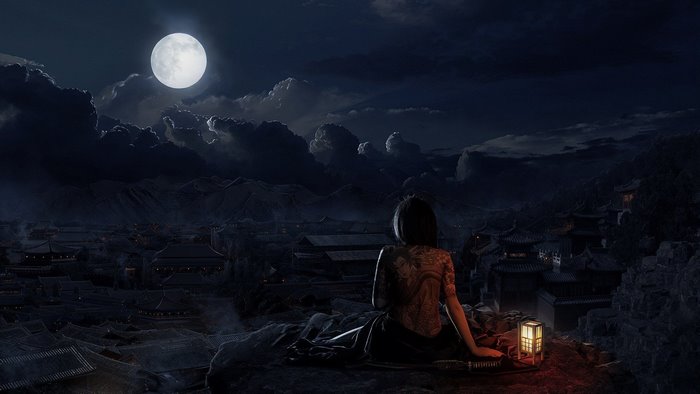 Woman with tattoo overlooking city at night under moon