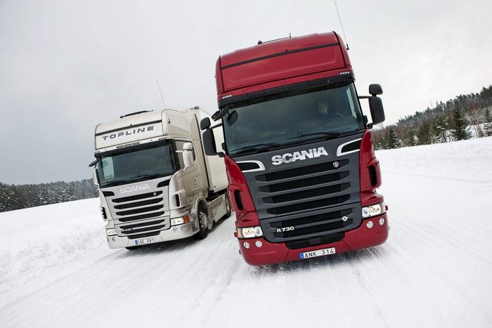 Two Scania trucks driving on a snowy road