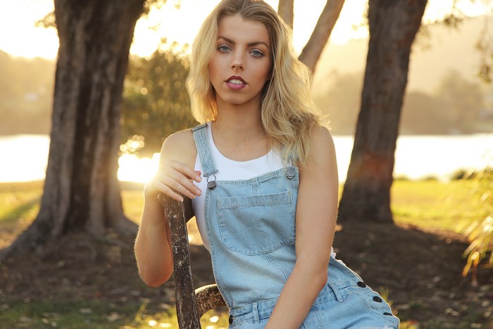 Woman in denim overalls at sunset