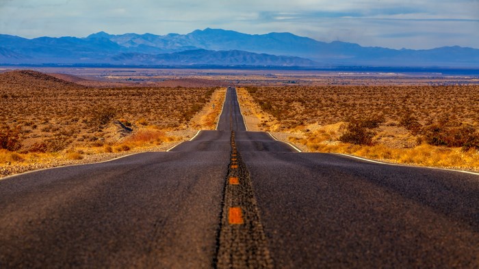 Desert highway leading to distant mountains