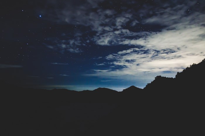 Silhouette of mountains under a starry night sky