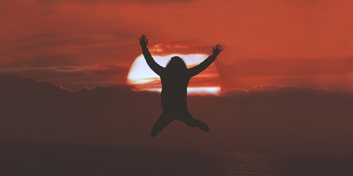 Silhouette of a person jumping at sunset