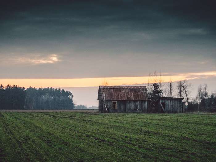 Barn in a field at sunset with clouds
