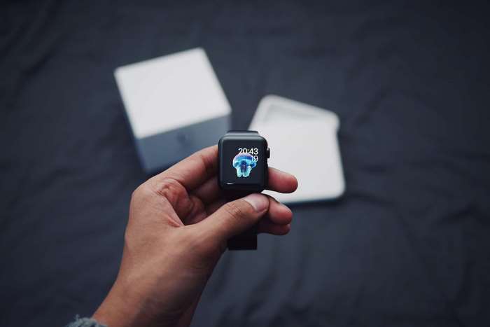Hand holding an Apple Watch with a jellyfish watch face